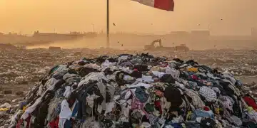 Gran pila de ropa desechada en un vertedero, representando el impacto de la moda rápida en México.